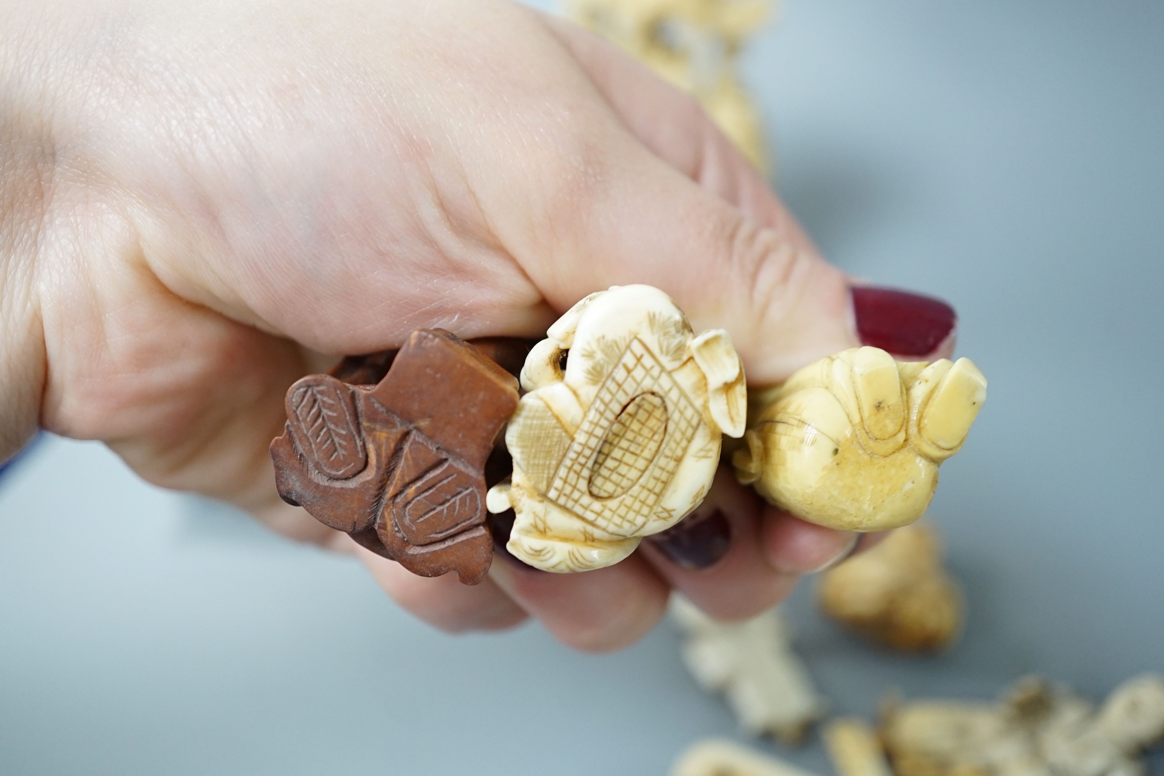 A collection of various ivory carvings including netsuke, a soapstone seal and carved wood netsuke